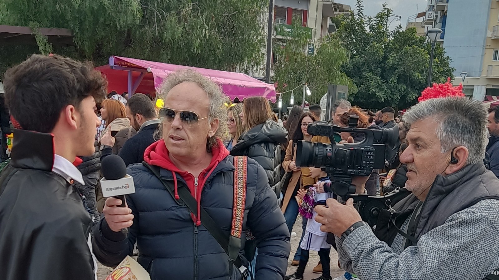 Una giornalista locale che intervista una persona all'aperto.